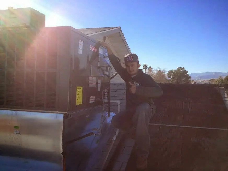 HVAC technician performing Air Duct Cleaning on a rooftop unit in Hillsboro